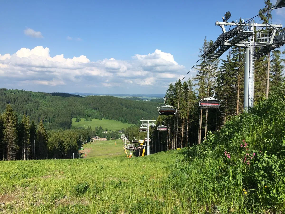Lanovka nad zelenými svahy v létě